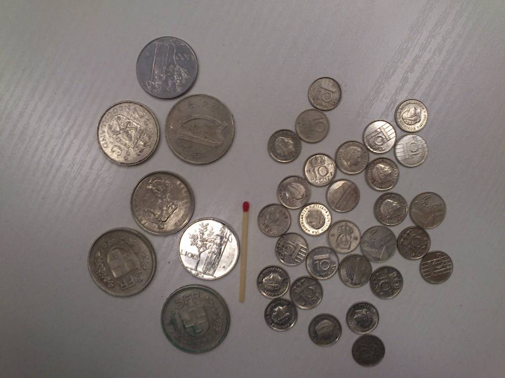 Kleine und grosse Münzen mit Streichholz abgebildet
