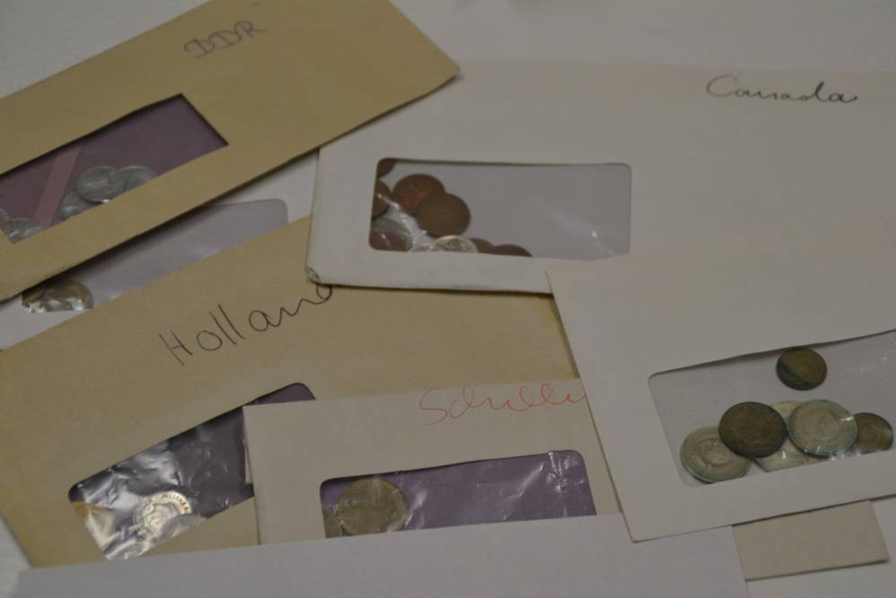 Briefumschläge mit Münzen aus diversen Ländern gefüllt